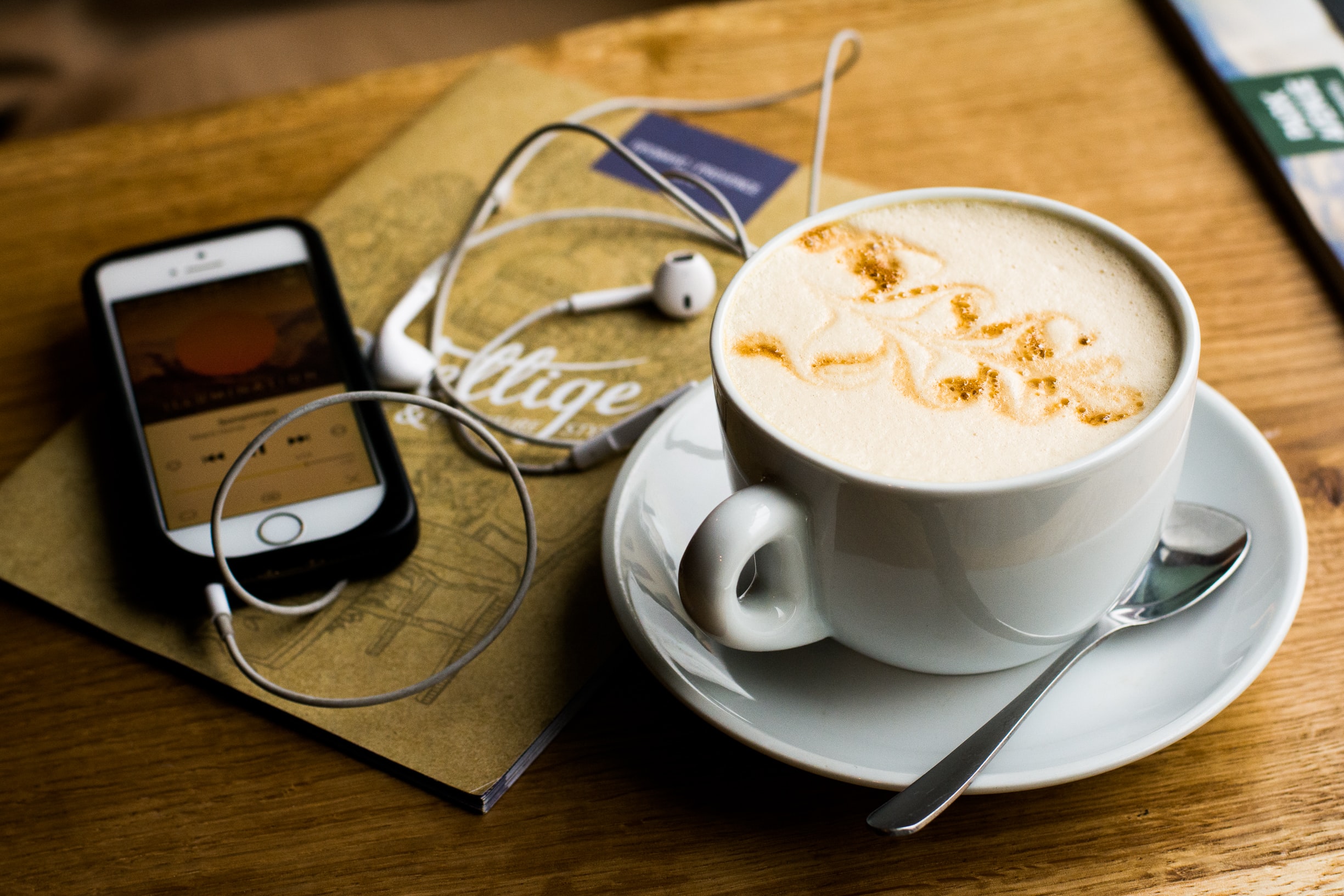 Image of phone and coffee - depicting listening to podcast