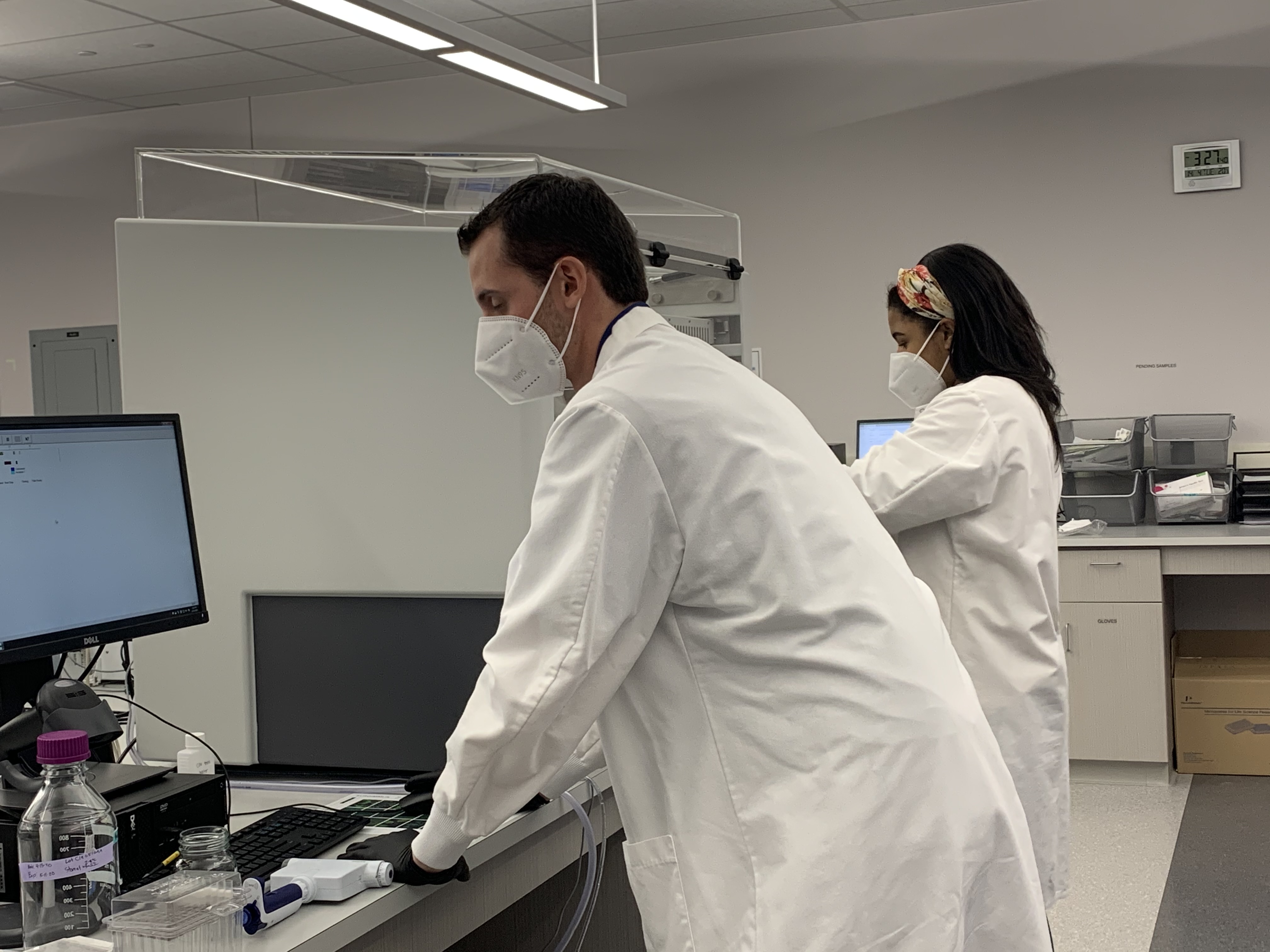 Two people in lab boats with masks on