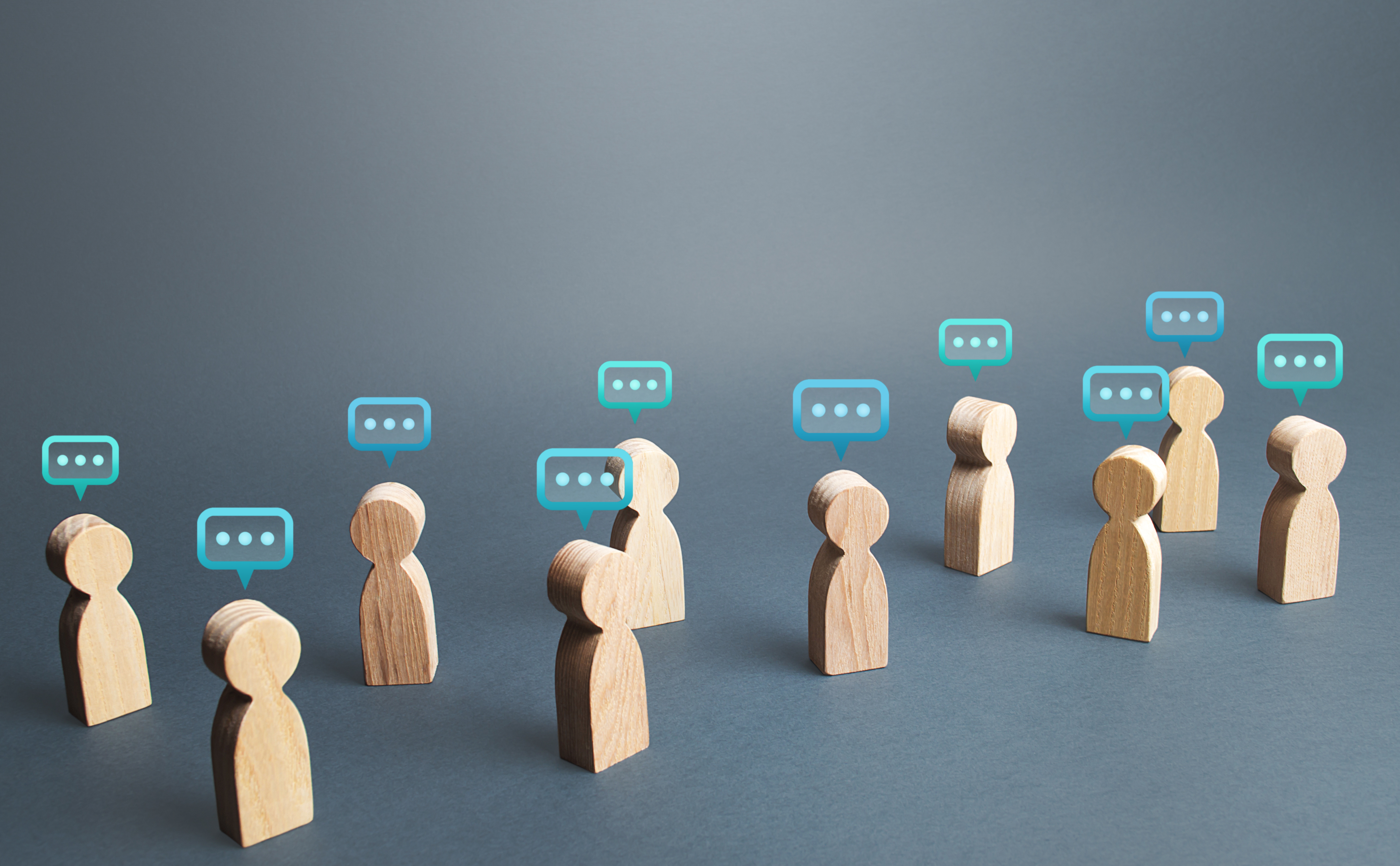 Wooden blocks representing people each with a speech bubble