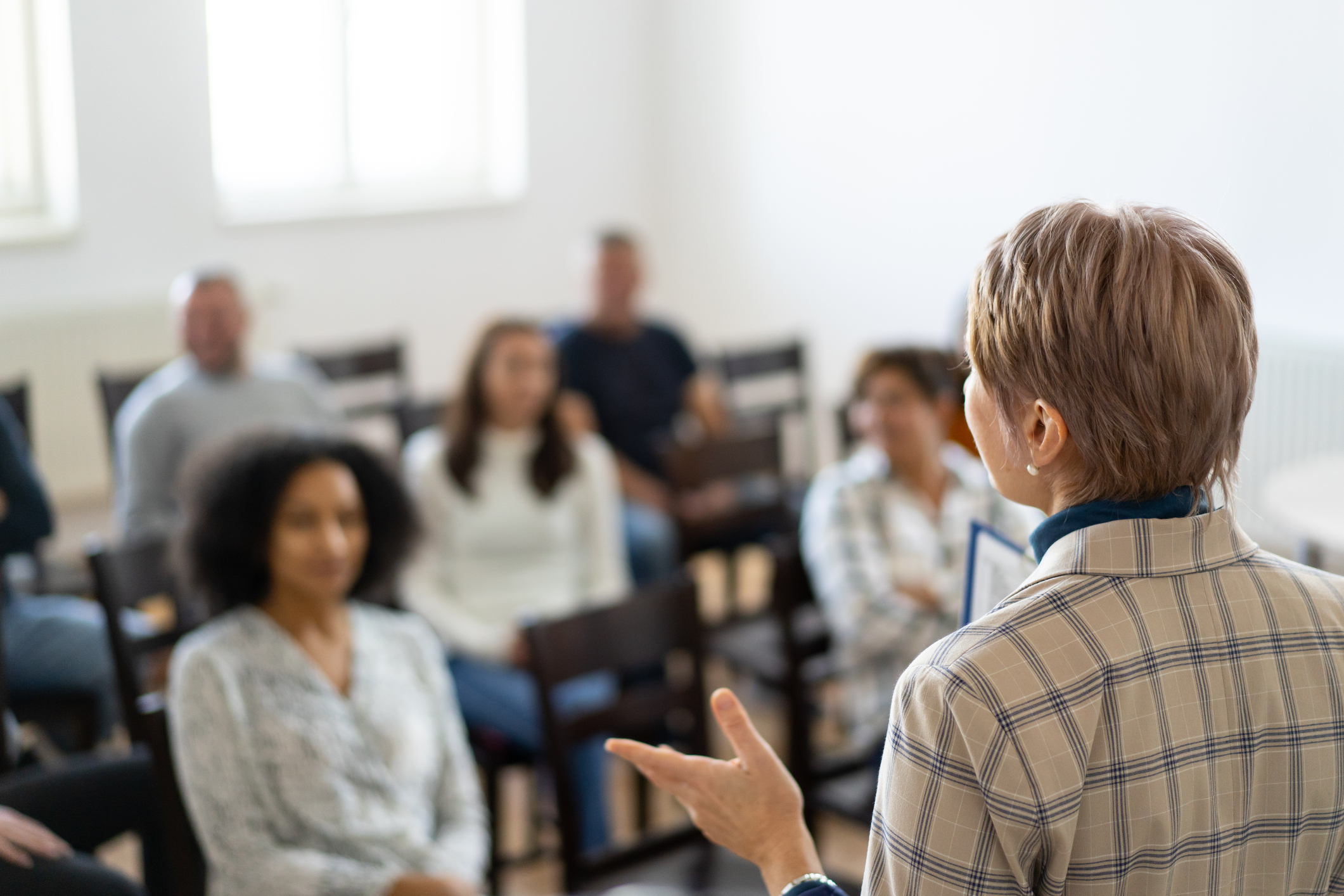 Woman standing in front of group of people presenting.