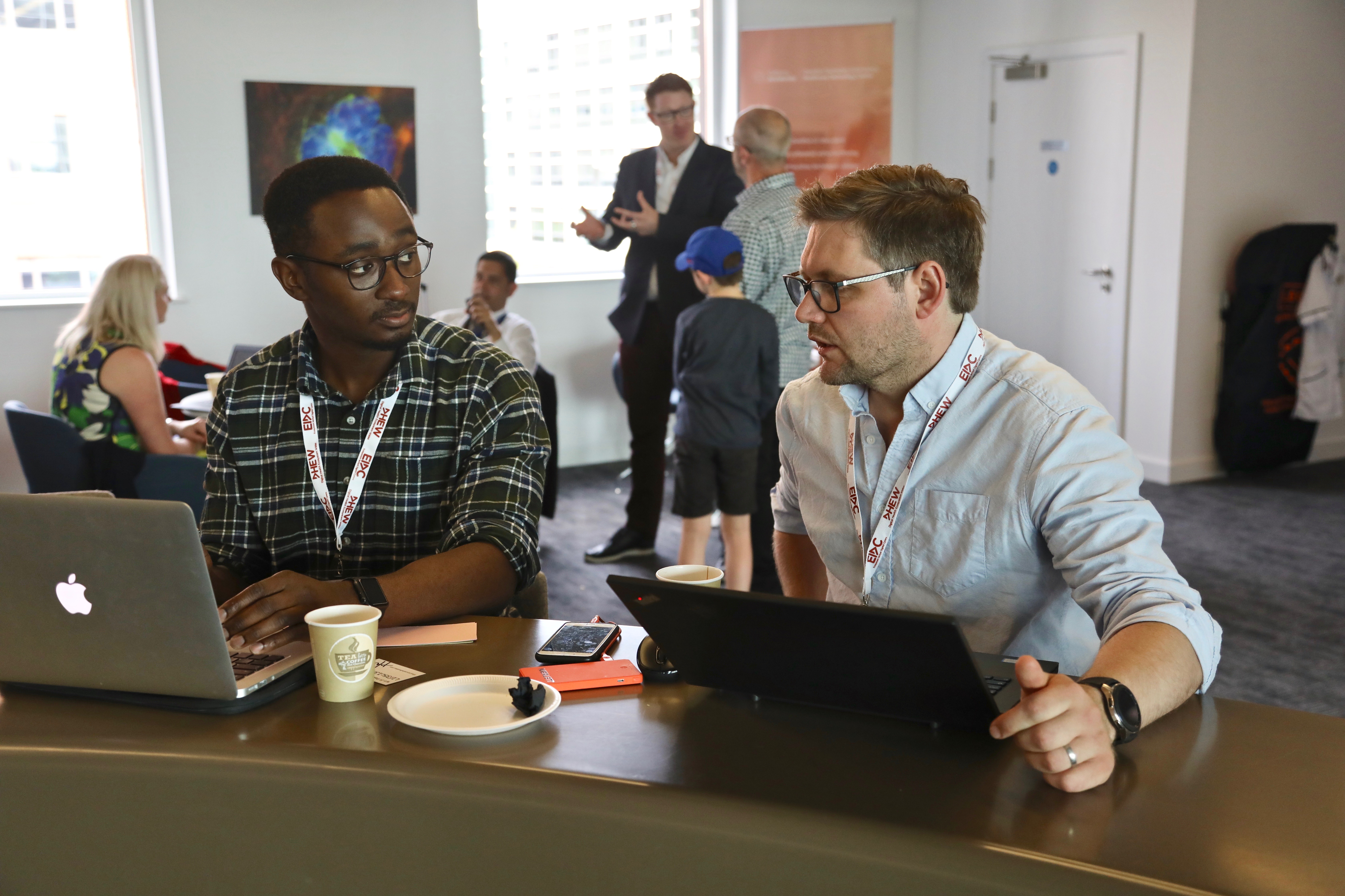 Two men networking at laptops