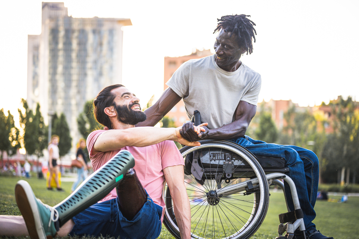 Two friends who have different physical disabilities greet each other