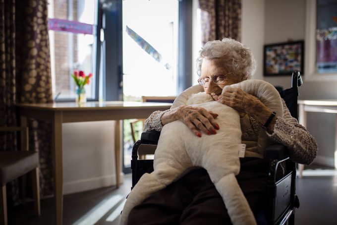 An elderly lade hugging the sensory therapeutic product created by HUG