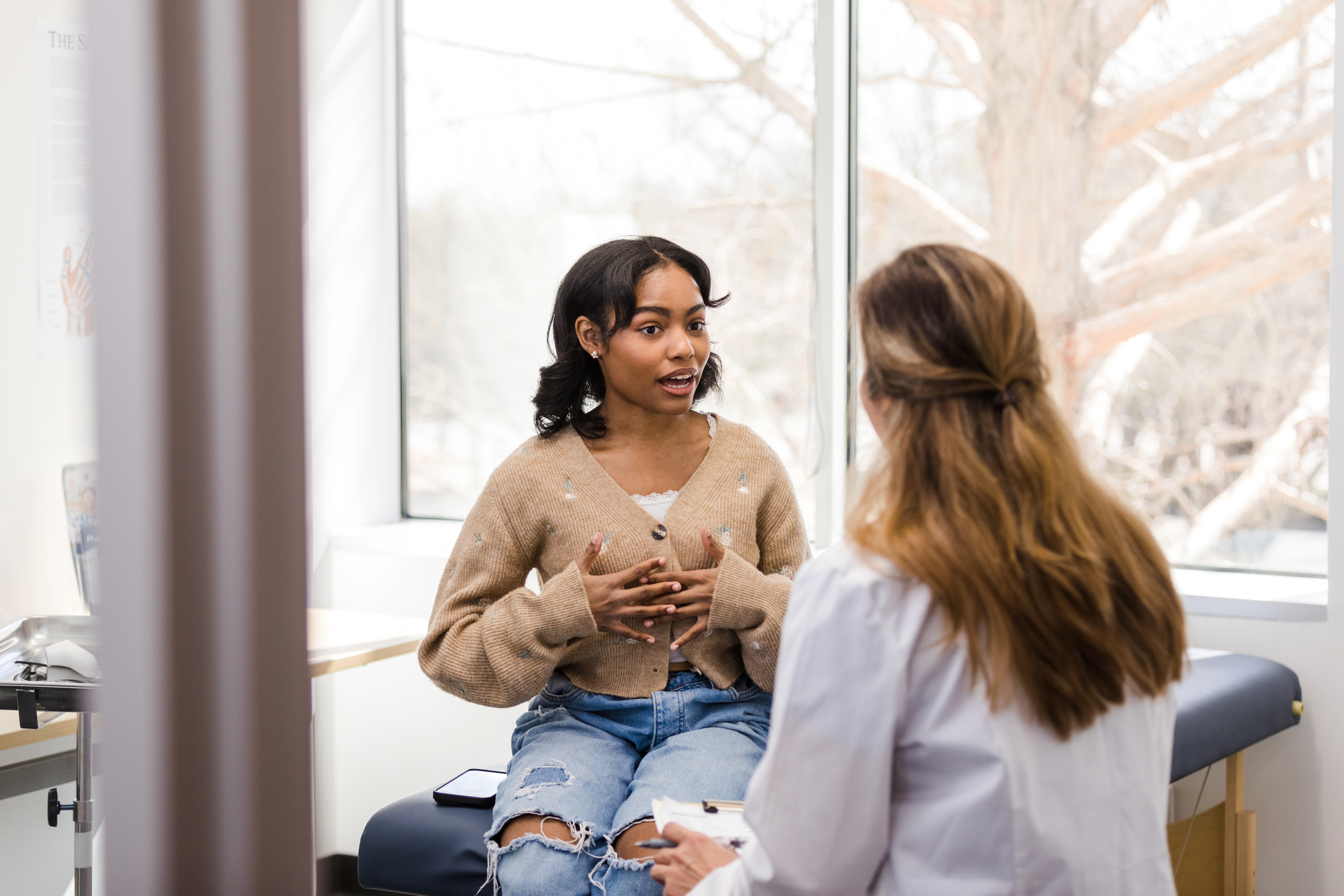 A young woman speaking to a doctor at a doctor's appointment