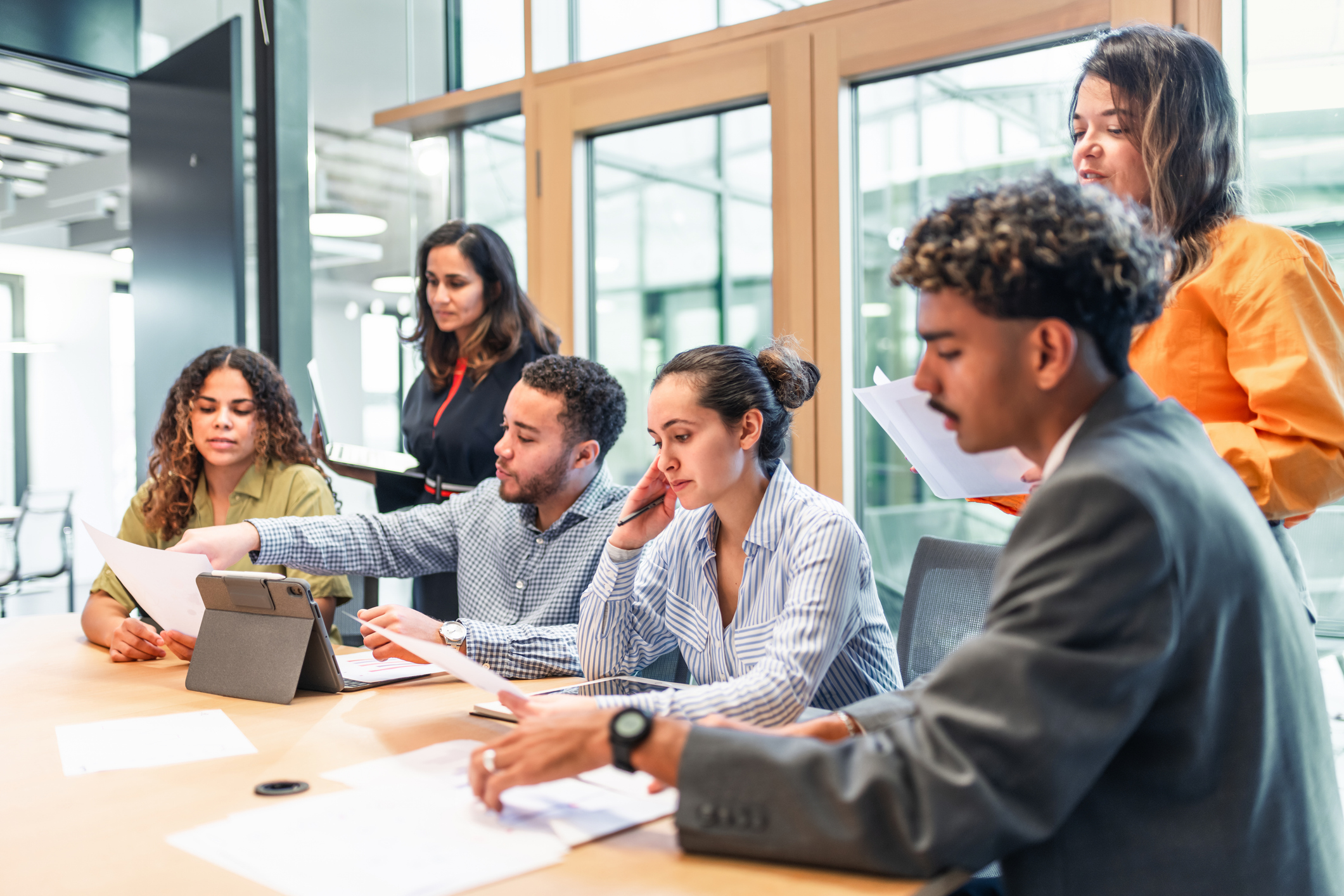 A group of people sitting around a laptop