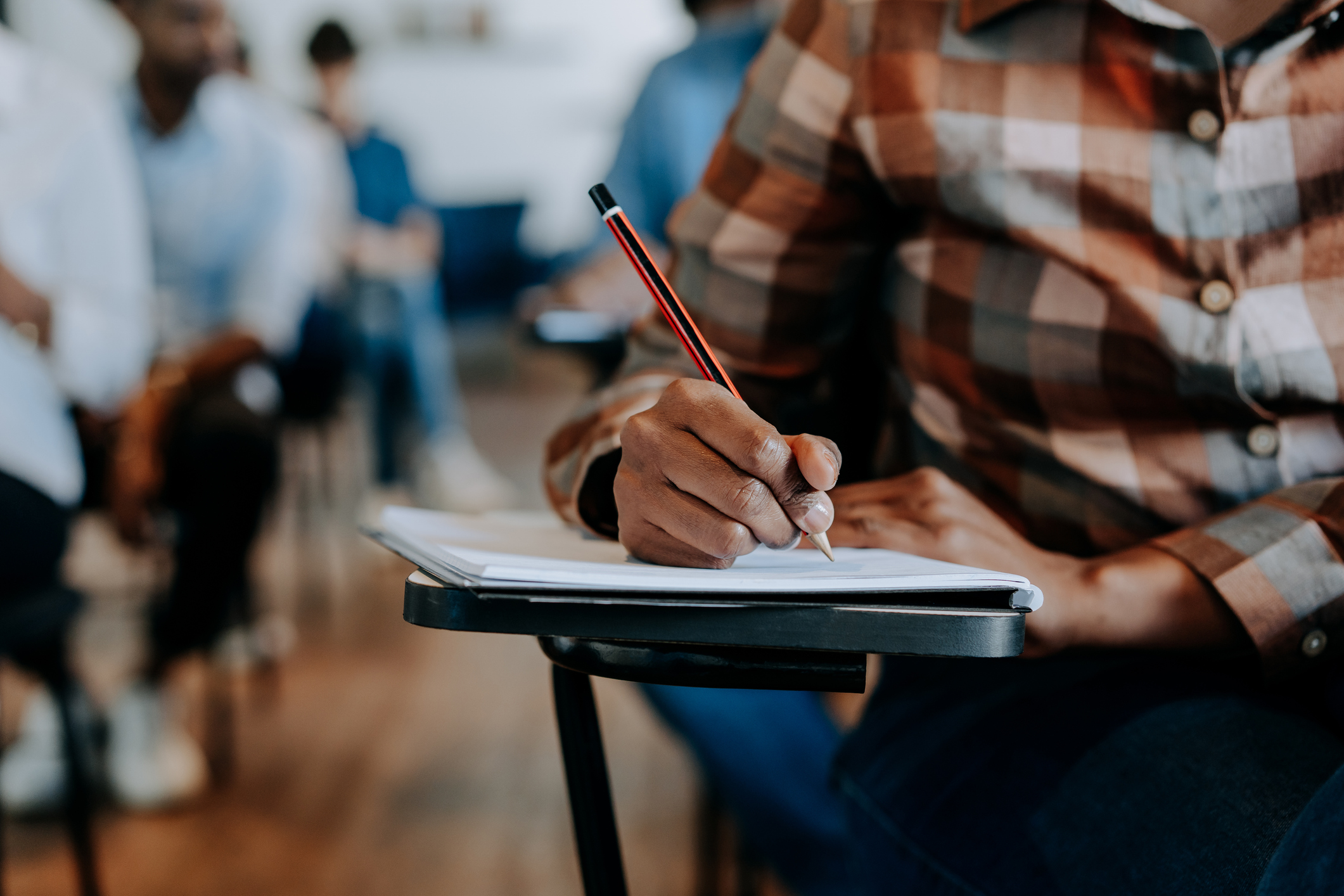 A person writing in a classroom