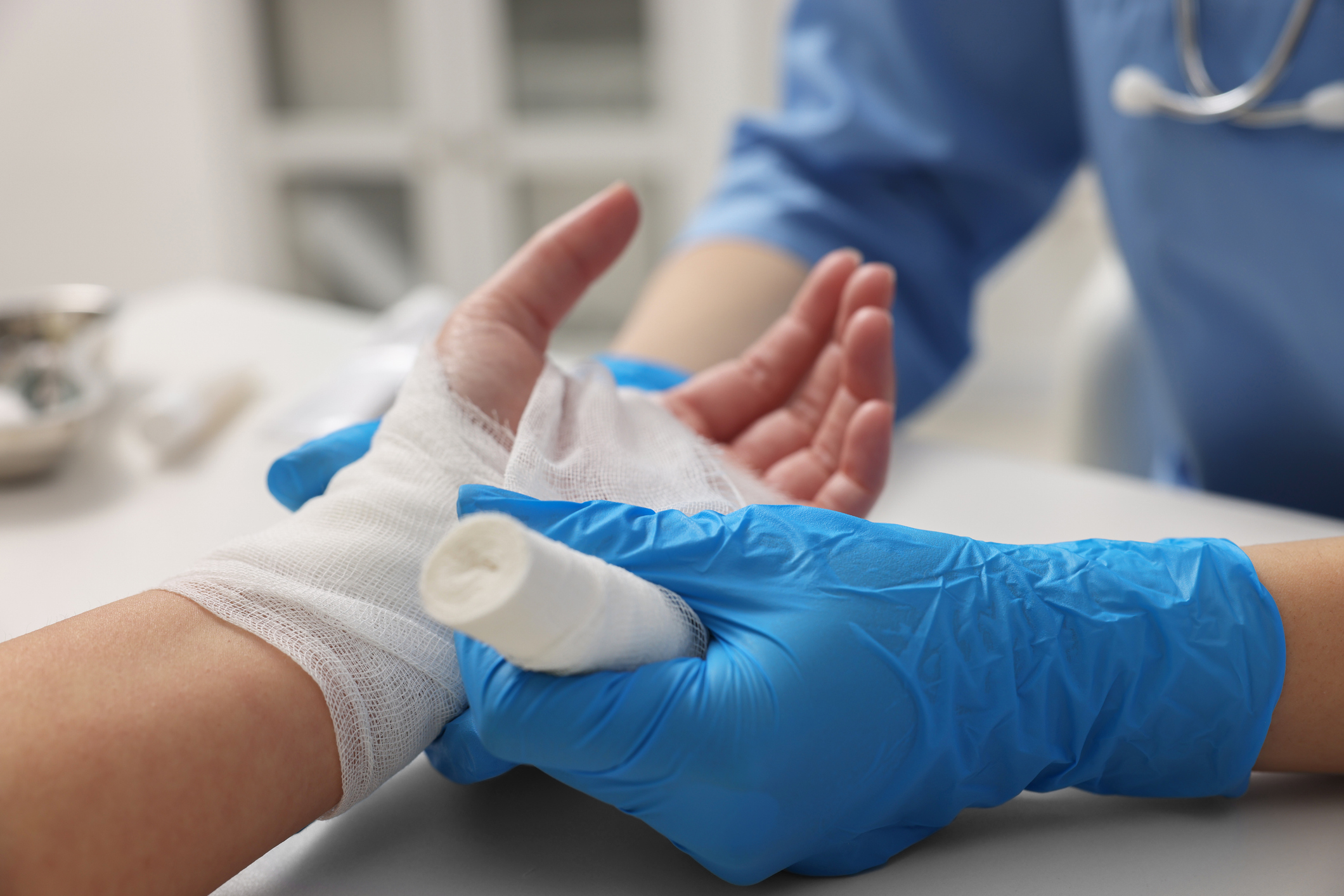 A clinician putting a bandage around someone's hand