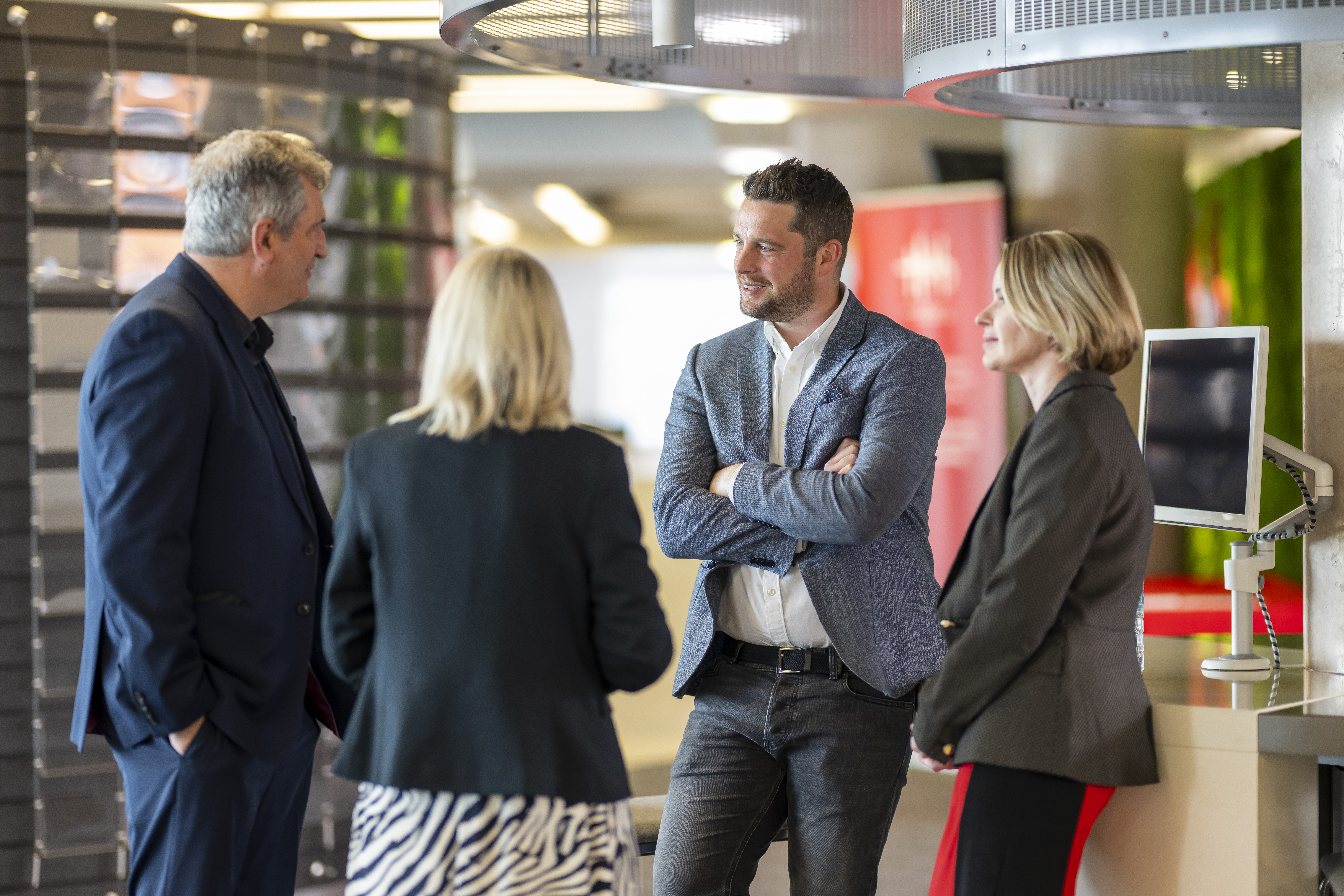 Two men and two women talking together at an event. 