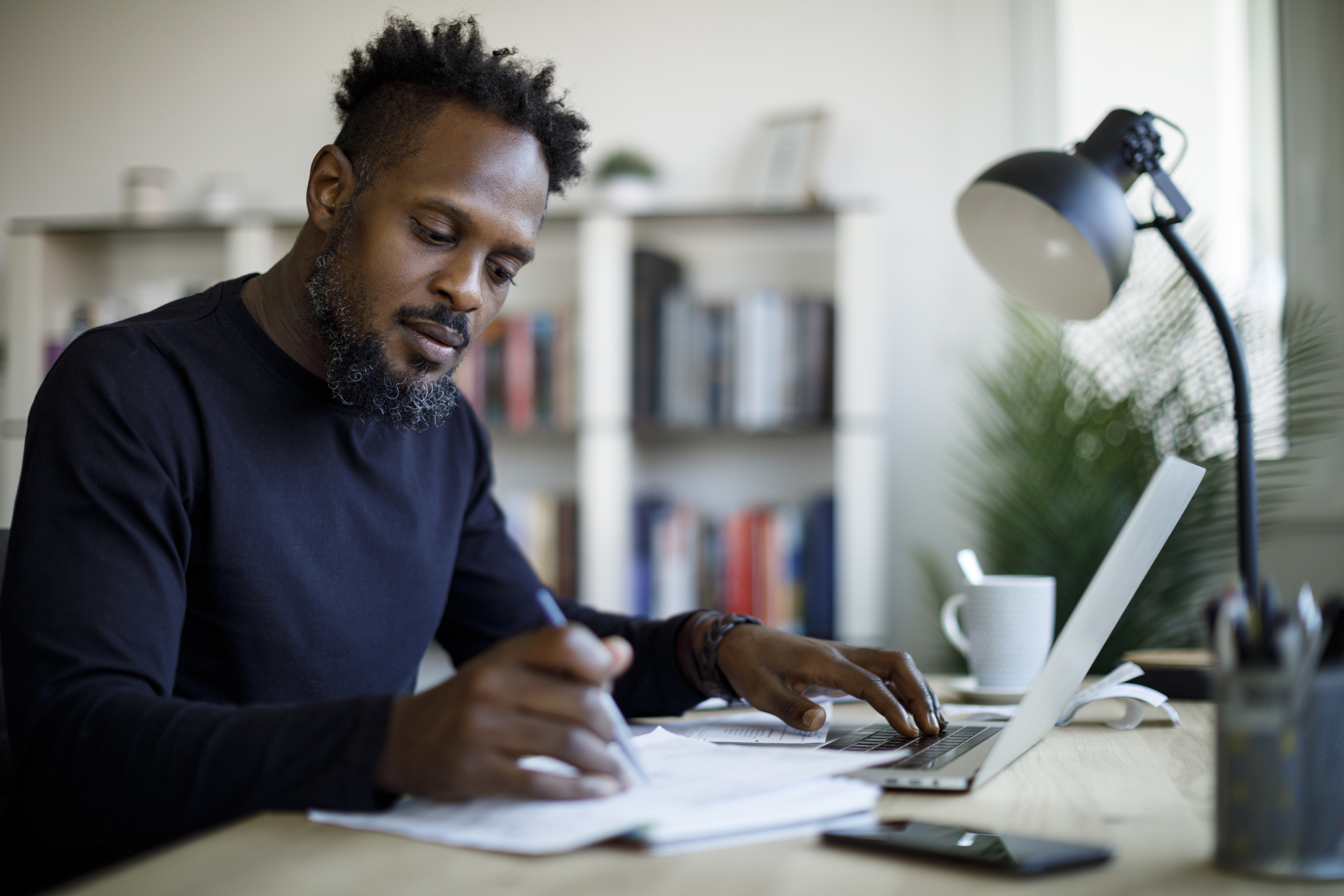 A man writing notes in an online meeting