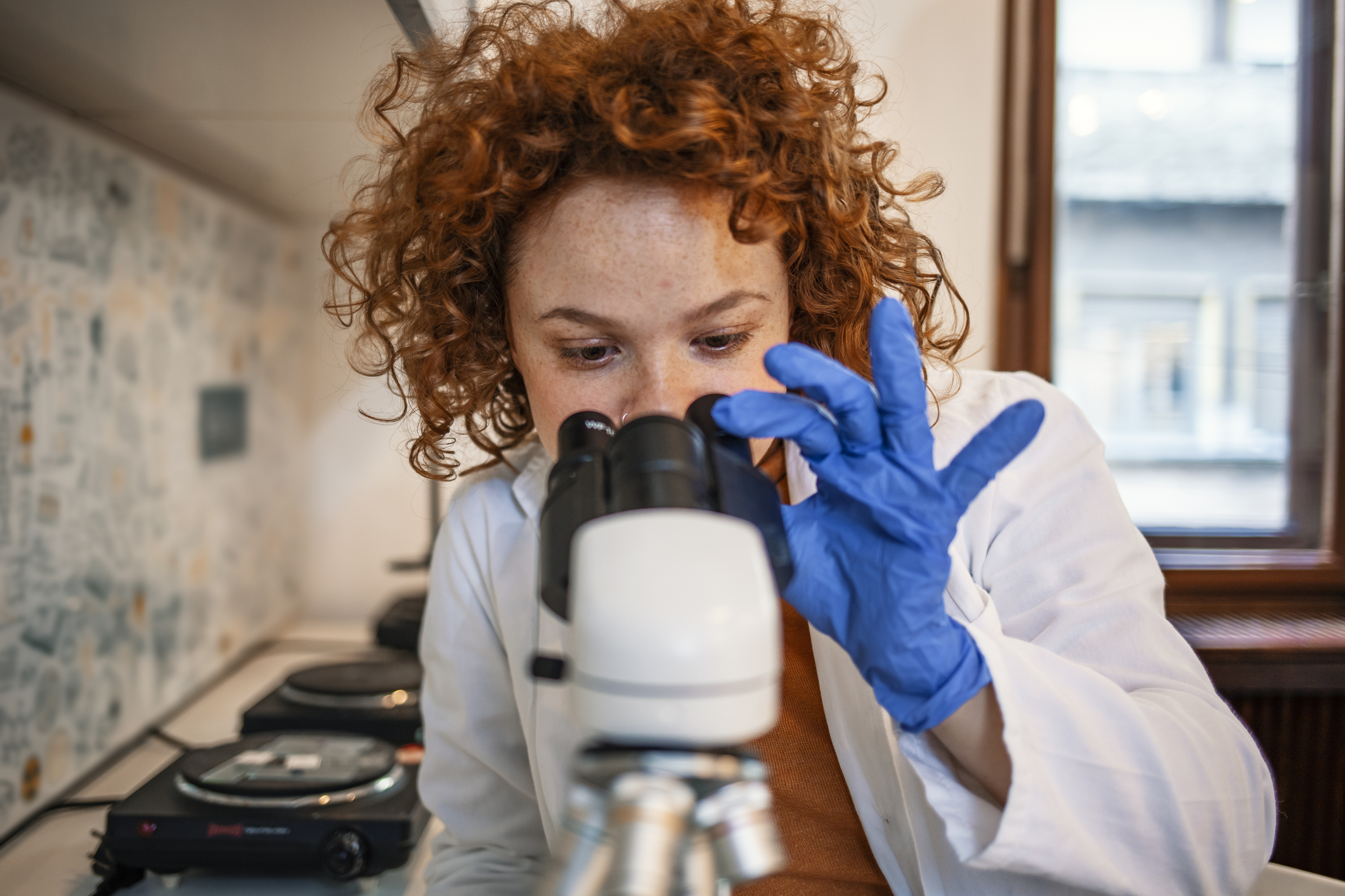 A woman looking down a microscope