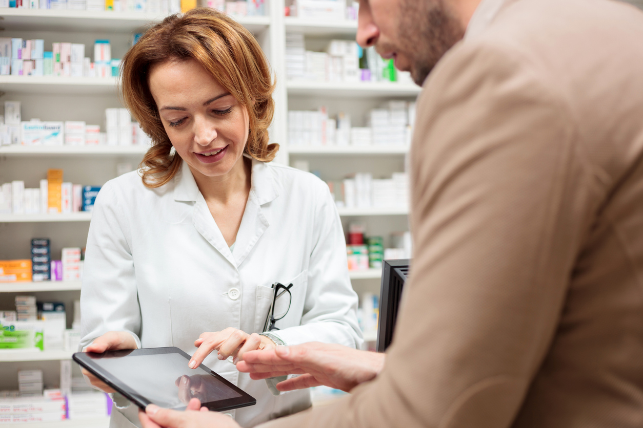 A pharmacist with a patient looking at an iPad