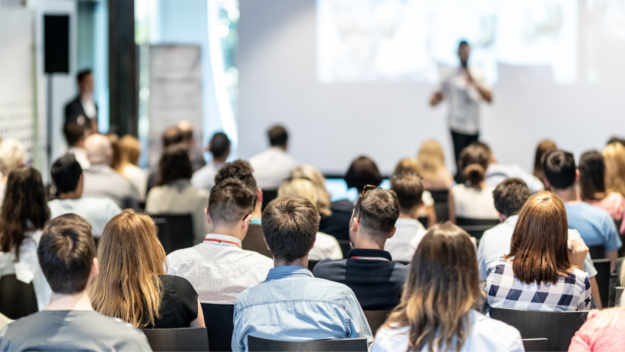 A conference room full of people watching a presentation