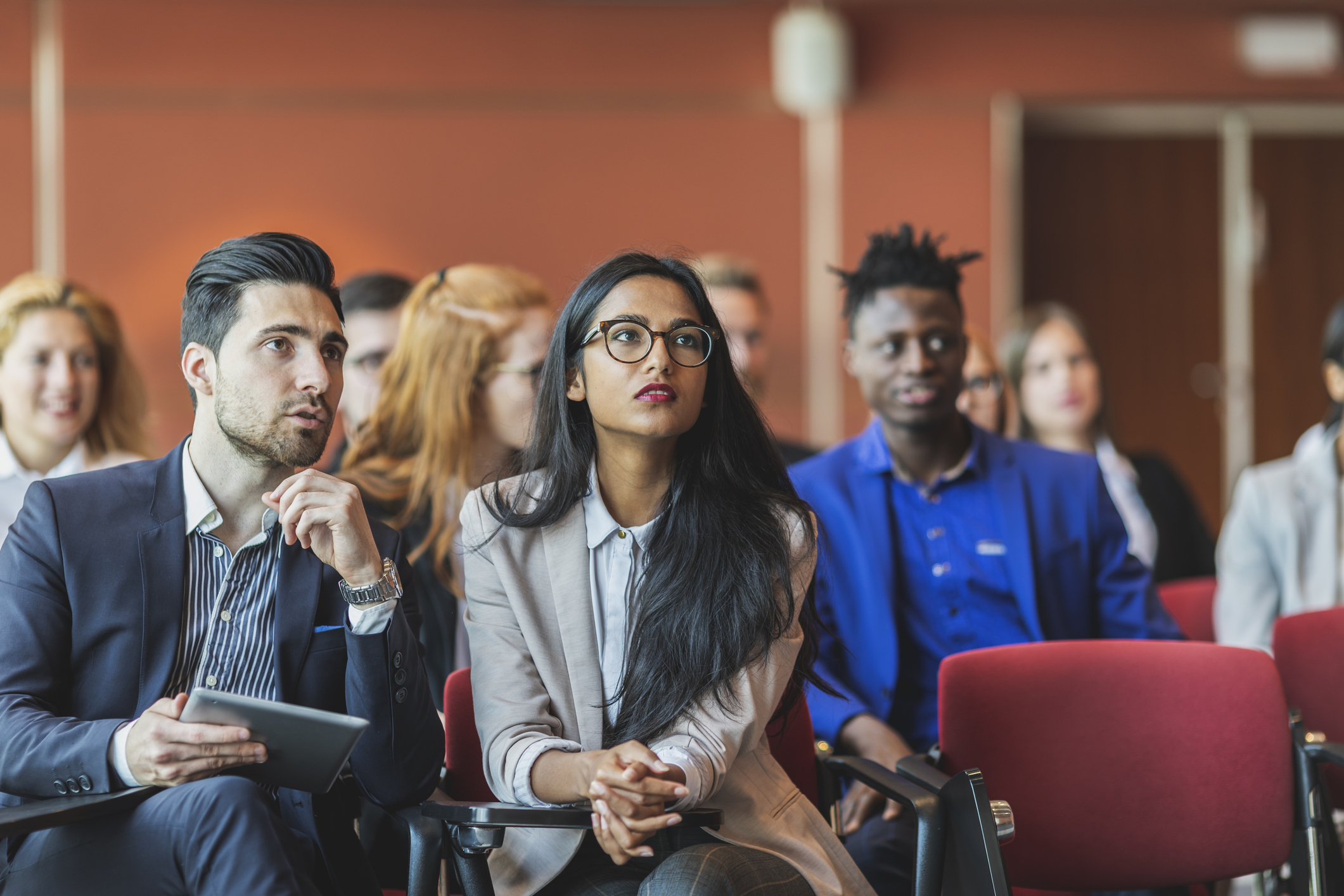 A group of people sitting and listening a conference