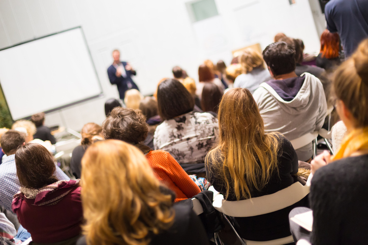A conference room full of people watching a presentation