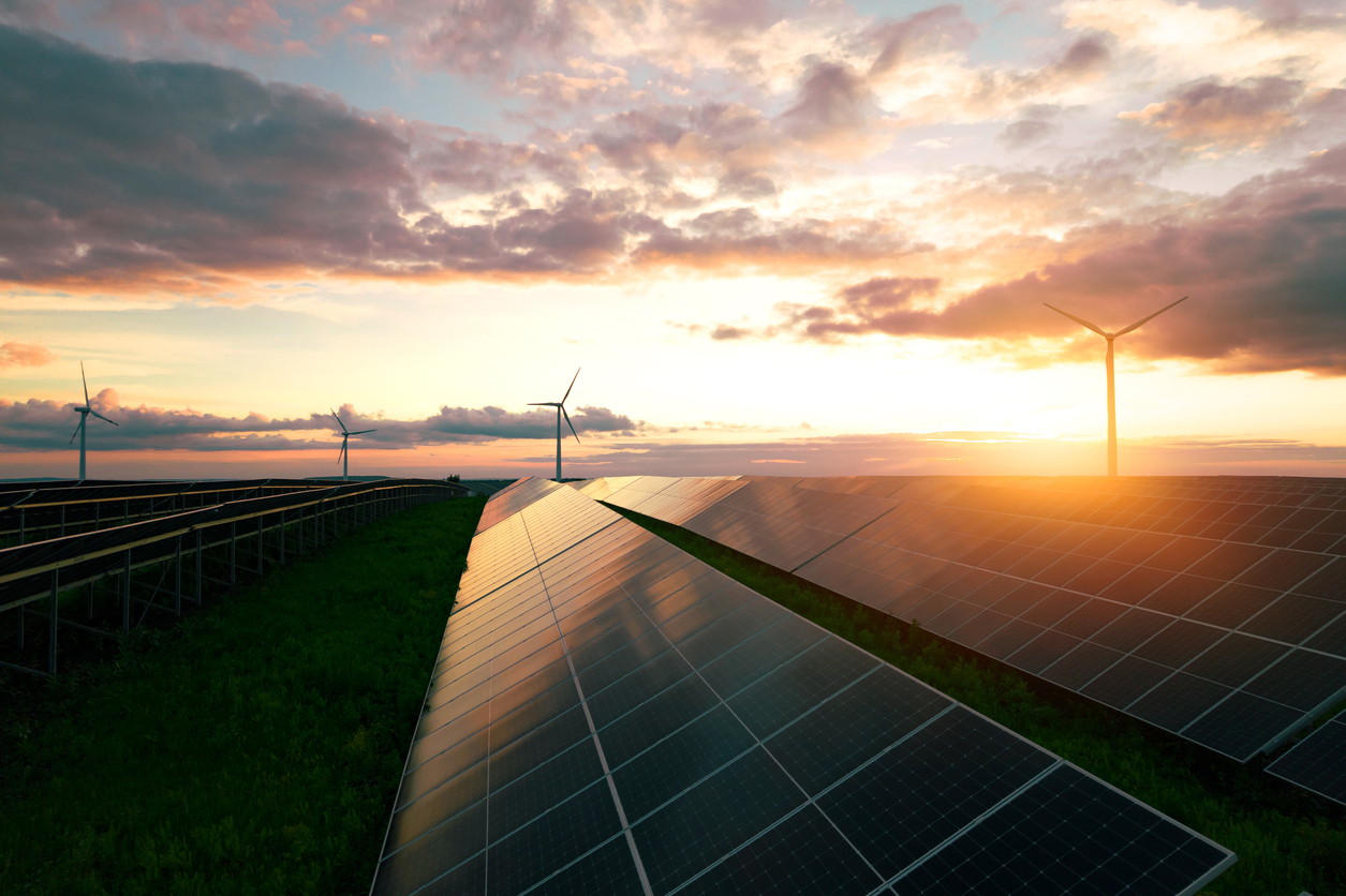 Windmill turbines and solar panels in a field.