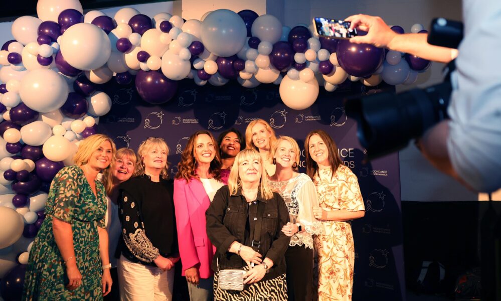 Group of people having their photo taken at an awards ceremony.