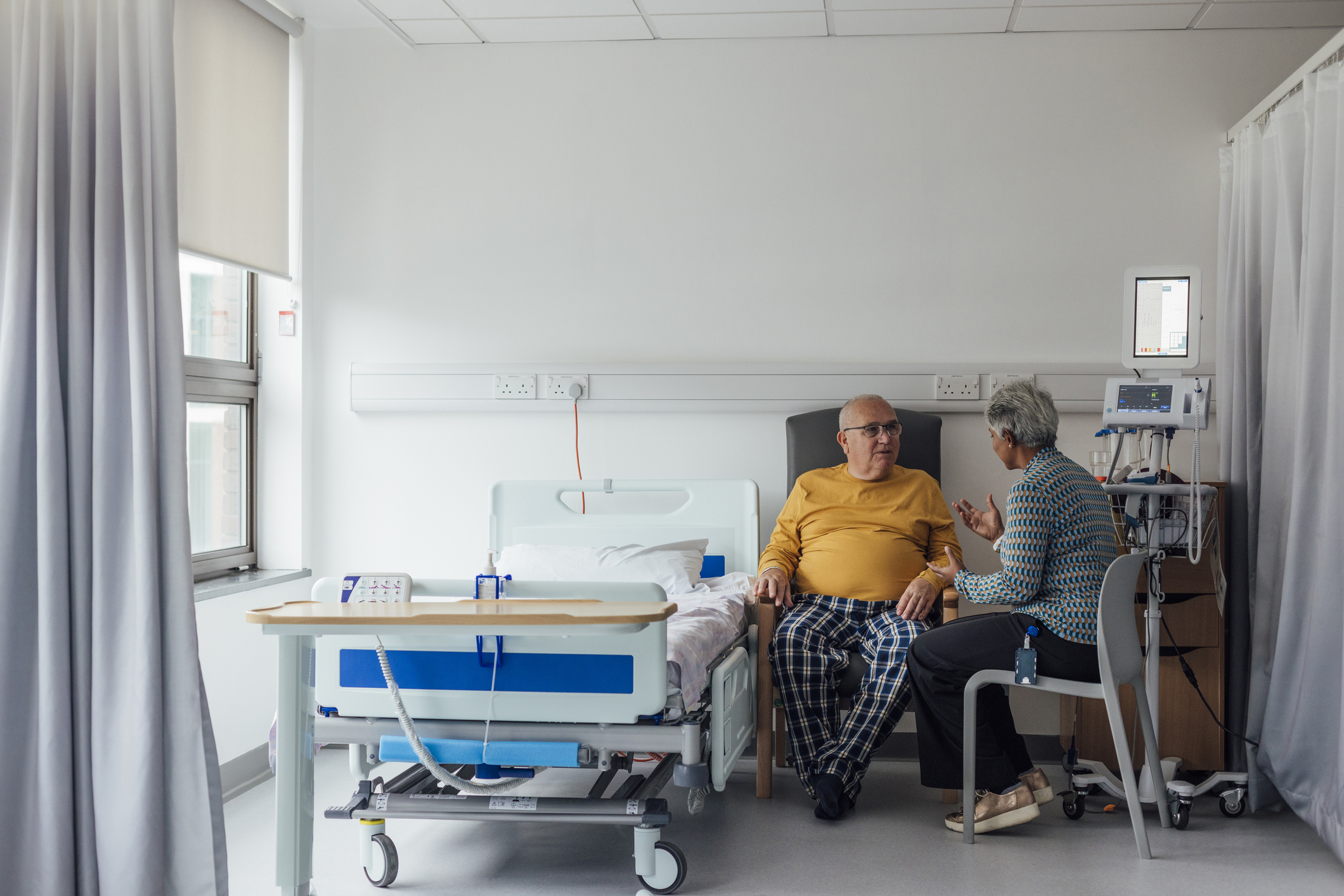 A senior male patient with cancer staying on a ward in a hospital.