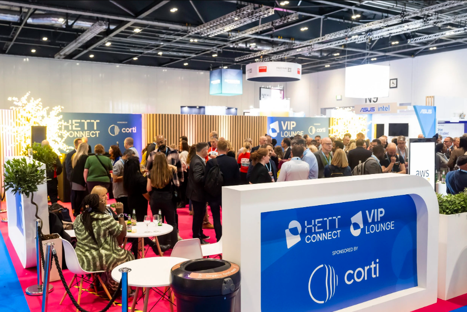 A cordoned off section of the HETT conference. There are around 100 people networking with drinks in hands.