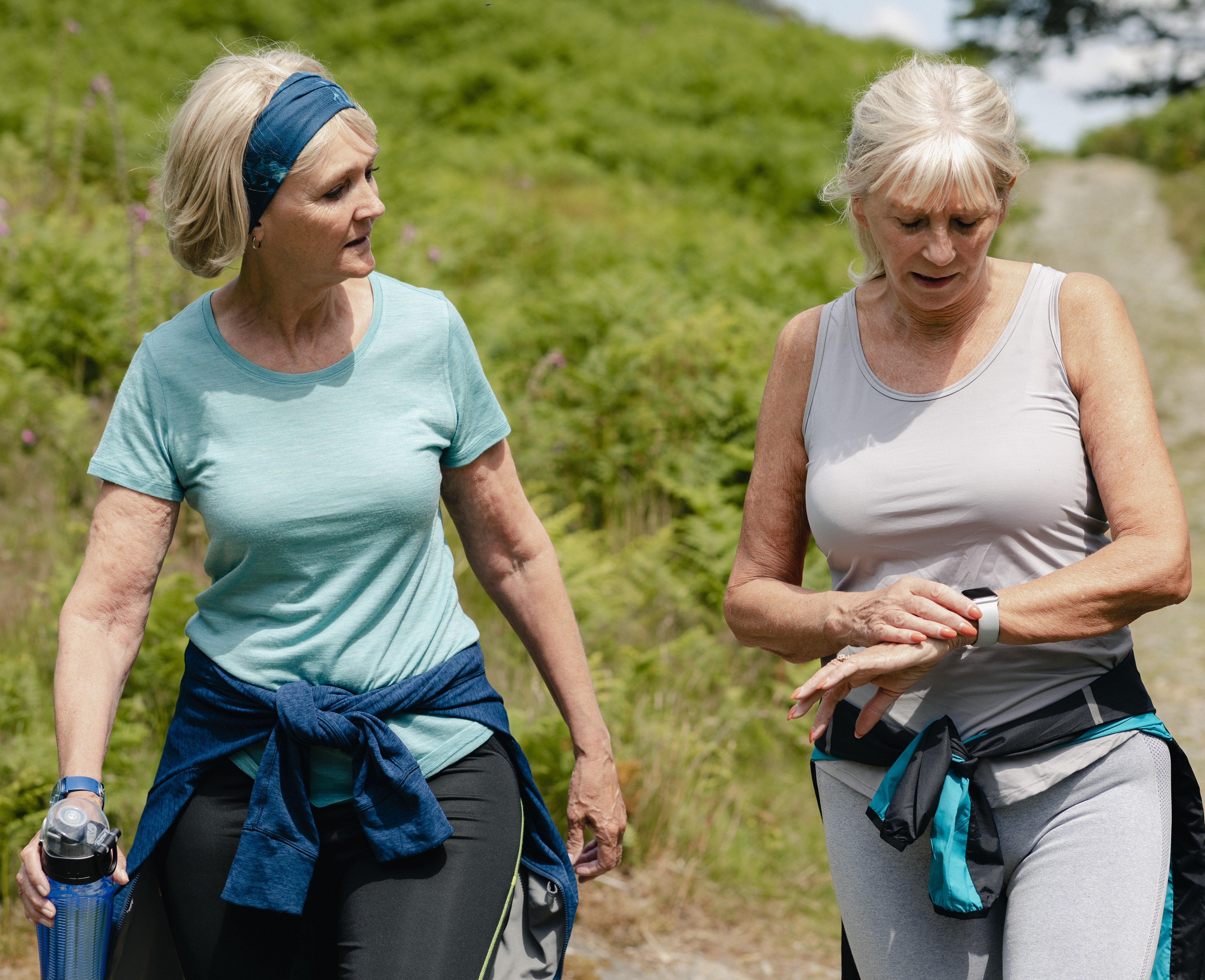 Two women walking in nature in sports gear